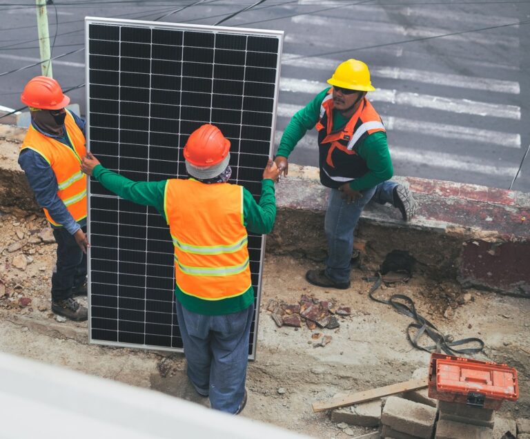 Workers in safety vests and hard hats installing a solar panel